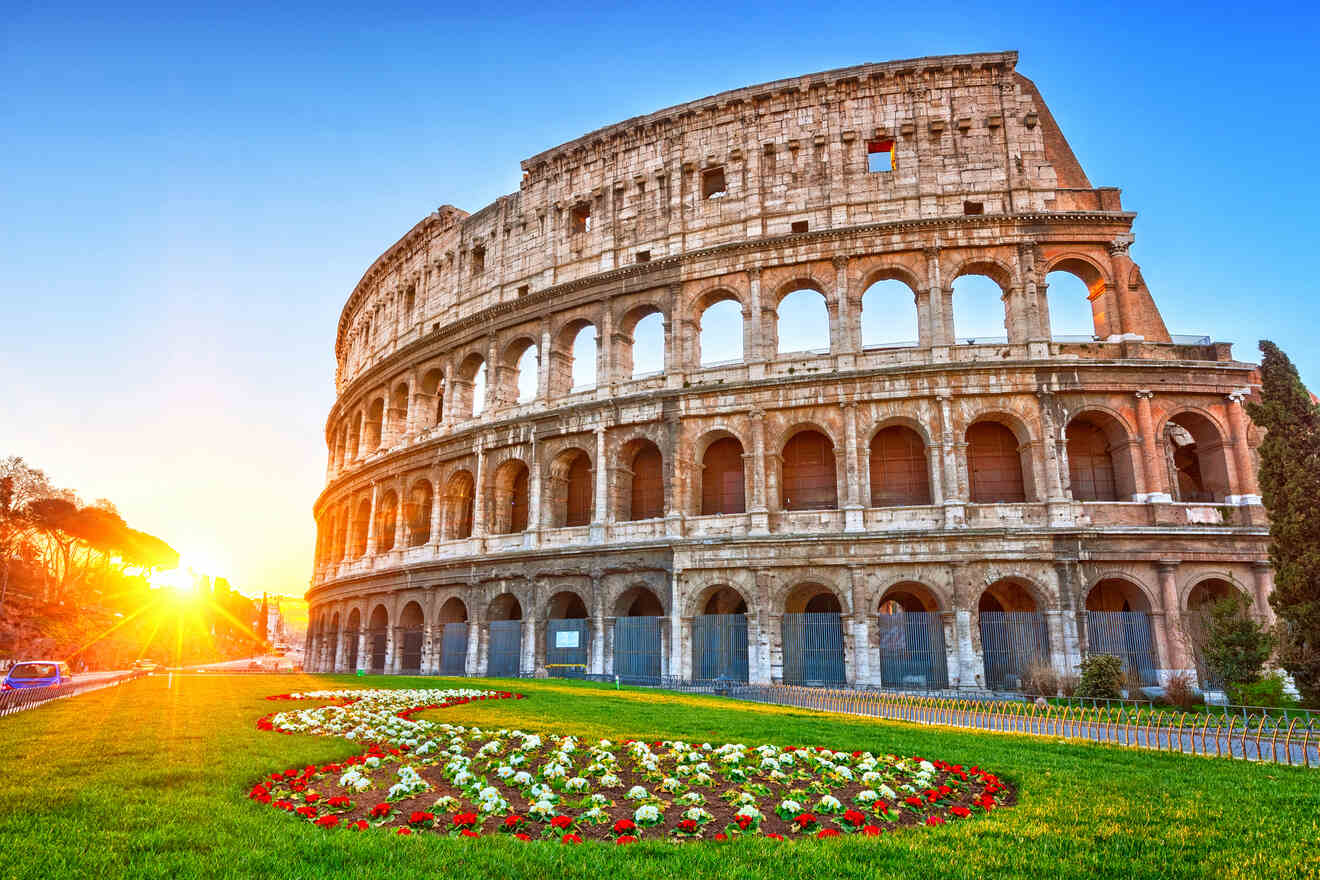 A view of the Roman Colosseum at sunrise with a manicured garden and colorful flowers in the foreground.