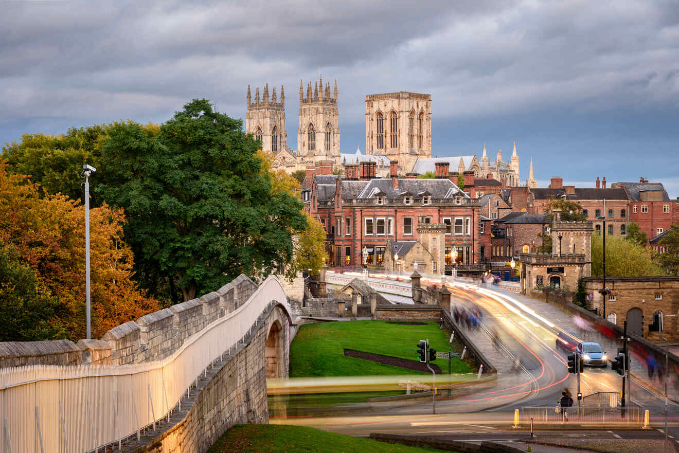 A cityscape view of York, featuring the historic York Minster cathedral in the background, busy streets, and a mix of old and modern buildings under a cloudy sky.