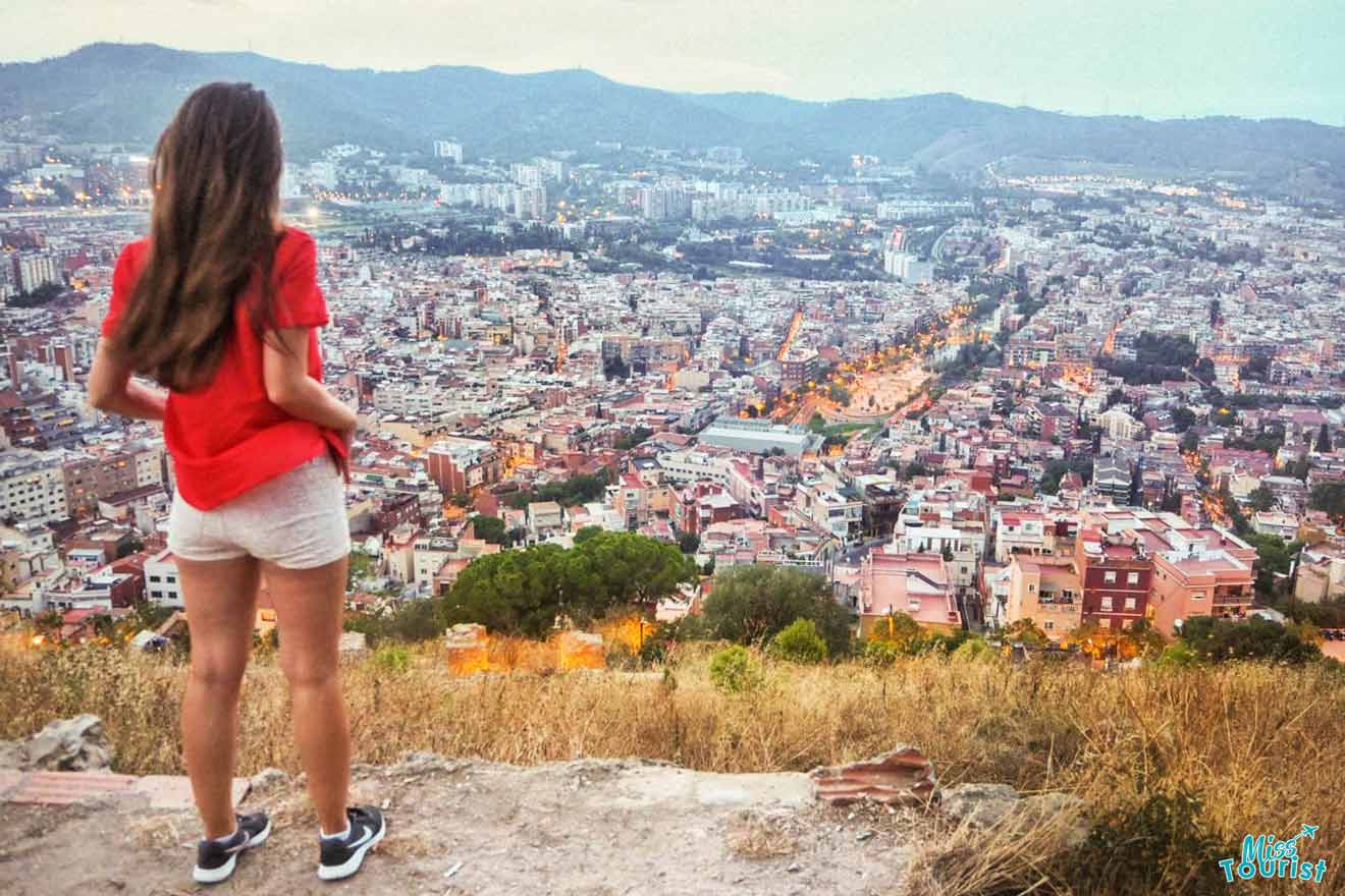 Yulia, the founder of this website, 
 is standing on a hill overlooking the city of barcelona.