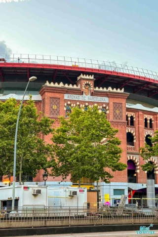 A red-brick building in front of trees, with a sign reading 