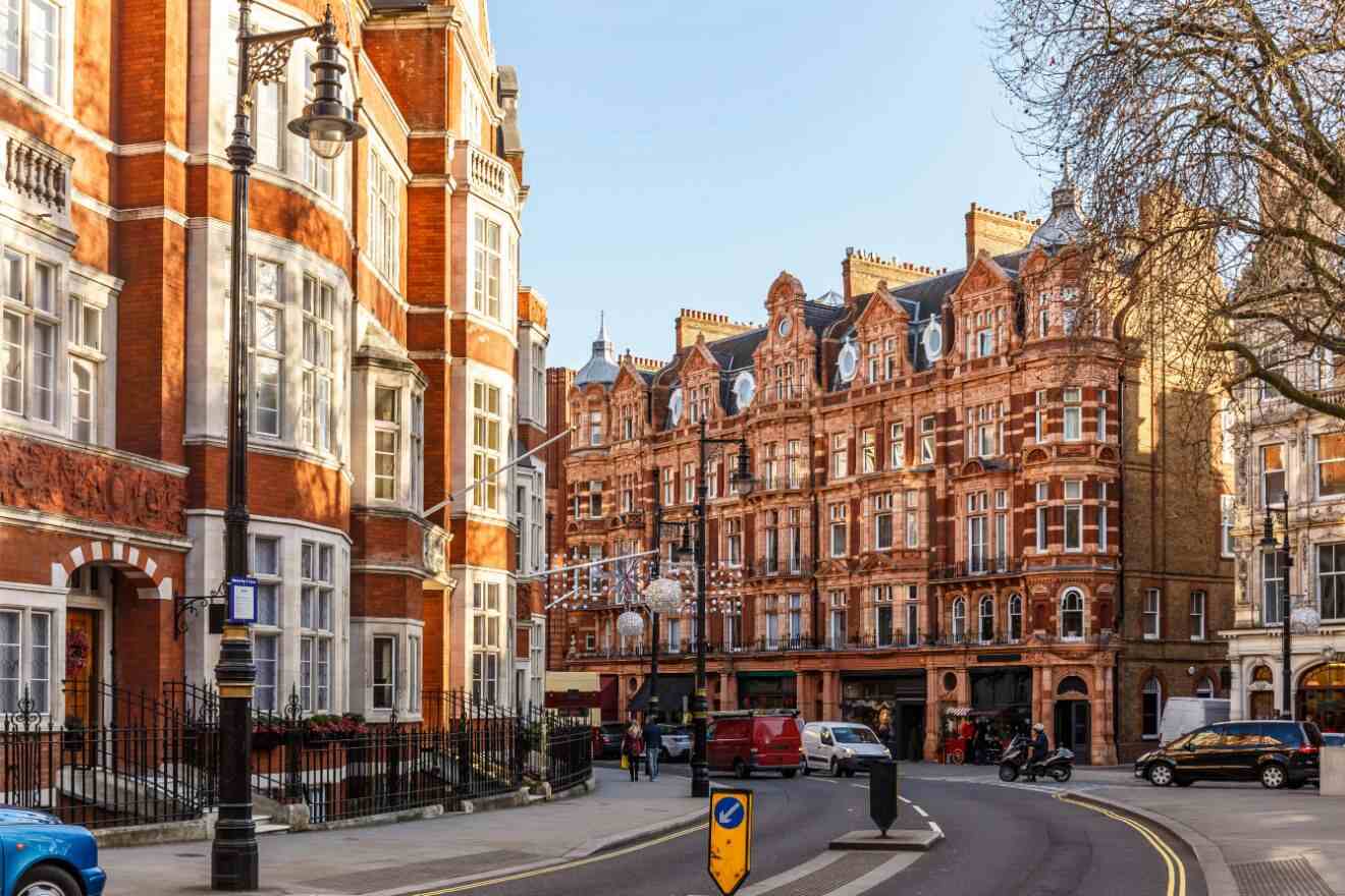 Red-brick Victorian buildings line a curved residential street in London, exemplifying the city's historic architectural charm