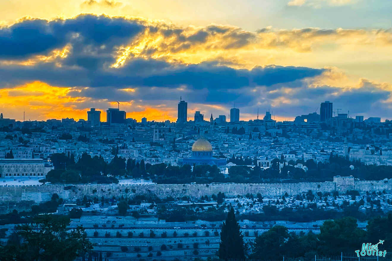 Silhouette of Jerusalem’s skyline at sunset, with the Dome of the Rock prominently visible amidst various buildings under a dramatic sky.