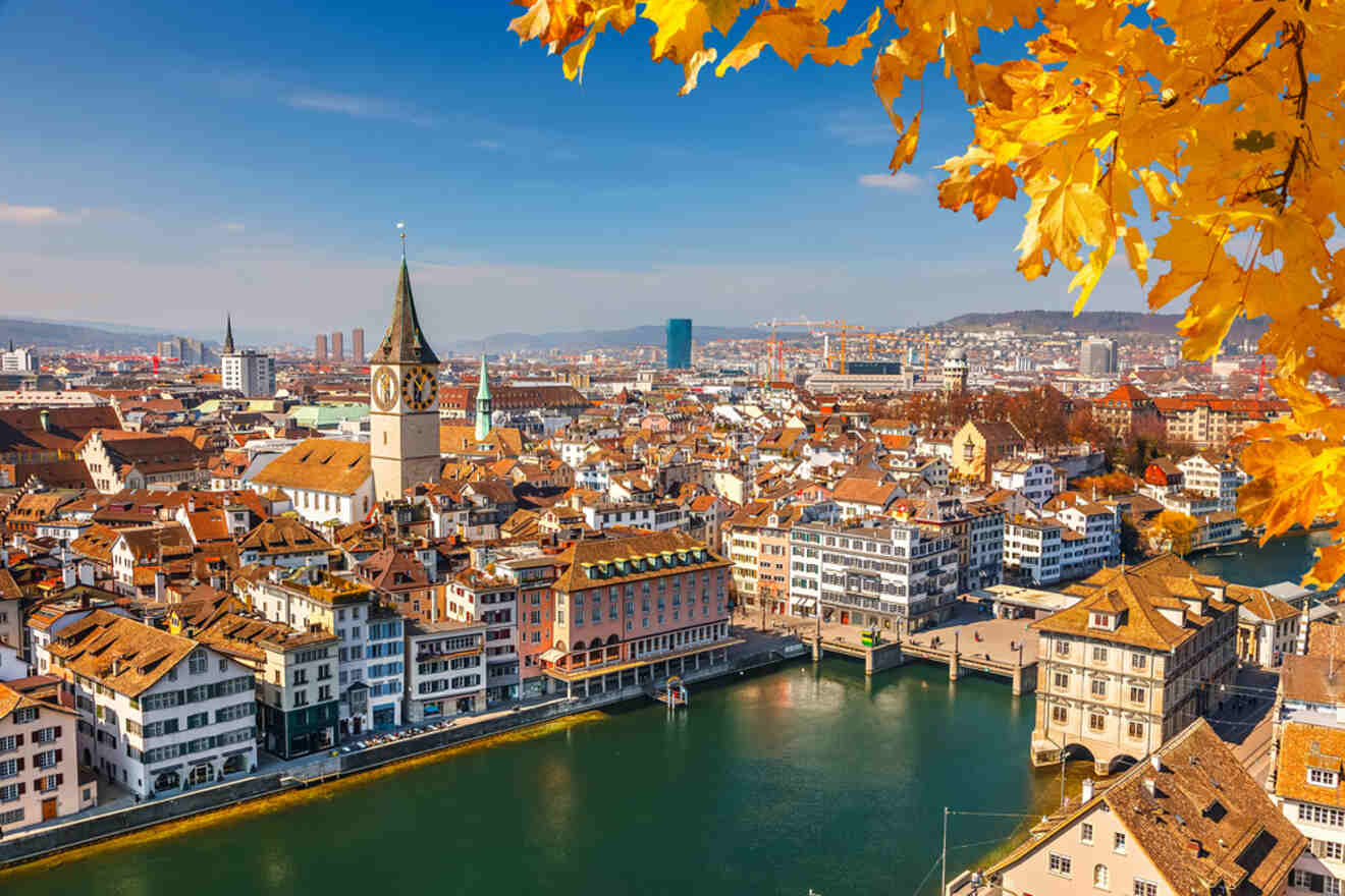 Autumn view of zürich's cityscape with the limmat river and classic swiss architecture under a clear blue sky.