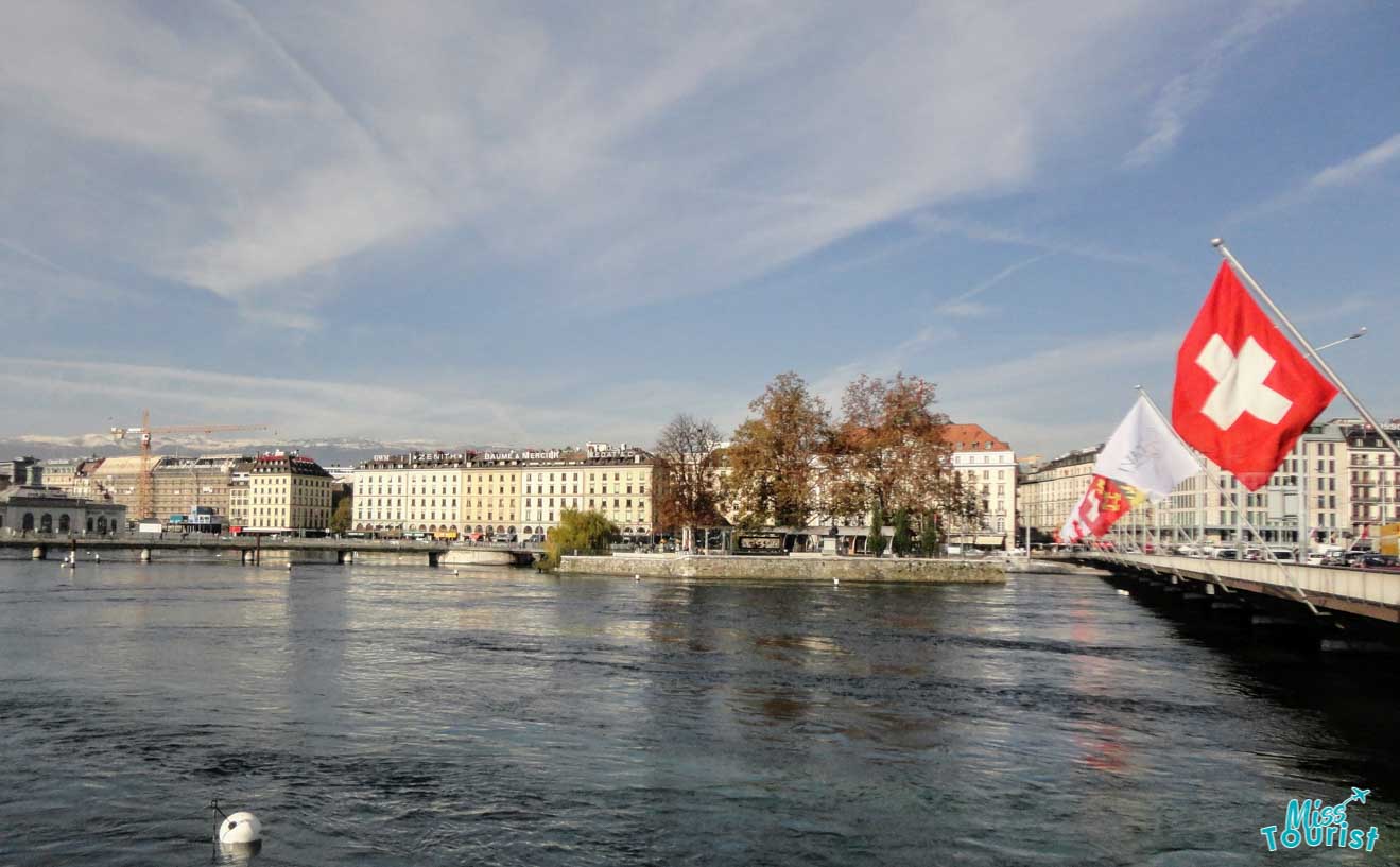 Scenic view of Geneva with Swiss flag fluttering on the Mont Blanc Bridge over the Rhône river