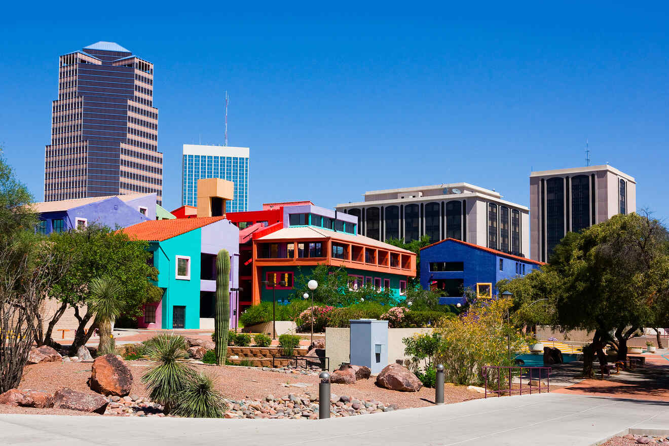 Colorful buildings in the foreground set against a skyline of modern office towers under a clear blue sky.