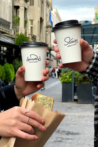 Two people holding coffee cups labeled 